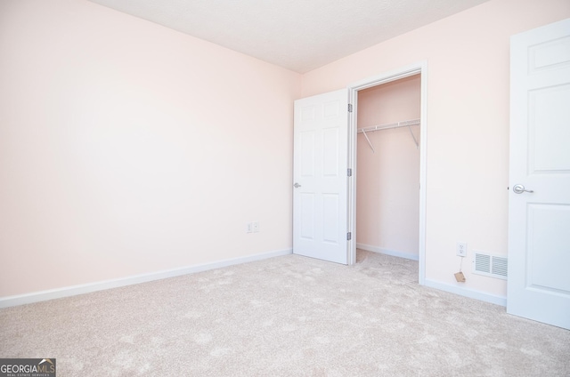 unfurnished bedroom featuring carpet floors, baseboards, visible vents, and a closet