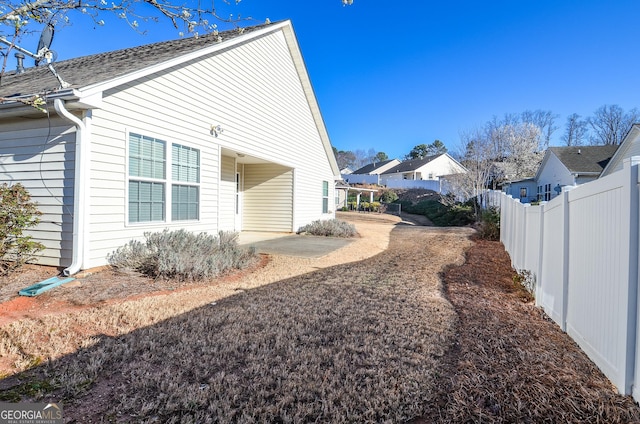 view of property exterior featuring a patio and fence