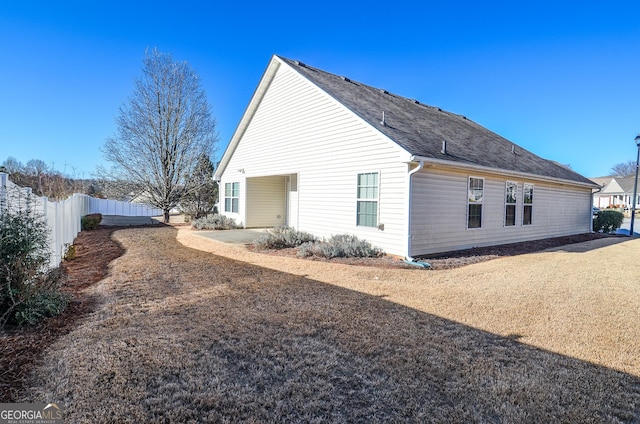 view of home's exterior featuring fence and roof with shingles