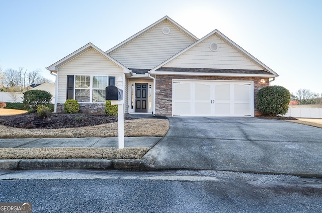 ranch-style house with stone siding, an attached garage, and driveway