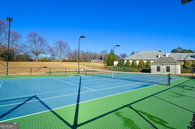 view of tennis court featuring fence and community basketball court