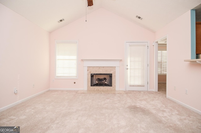 unfurnished living room with a premium fireplace, visible vents, carpet floors, and ceiling fan