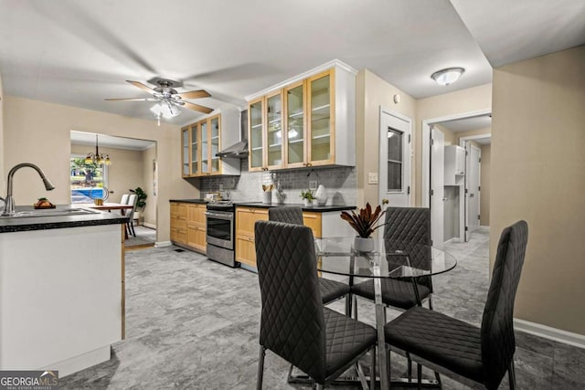 dining room with indoor wet bar, baseboards, and ceiling fan with notable chandelier