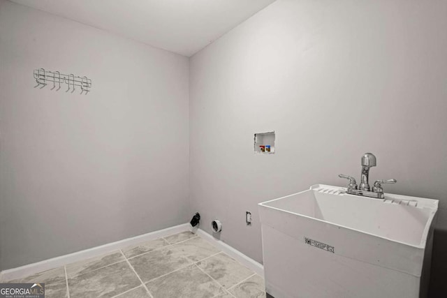 laundry room with laundry area, a sink, baseboards, and washer hookup