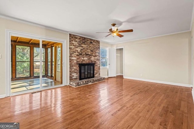 unfurnished living room featuring baseboards, hardwood / wood-style flooring, ceiling fan, and ornamental molding