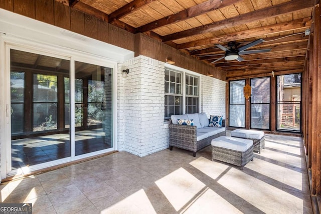 unfurnished sunroom featuring beam ceiling, wood ceiling, and ceiling fan