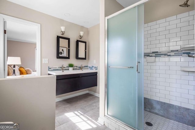 full bathroom featuring a shower stall, baseboards, and double vanity