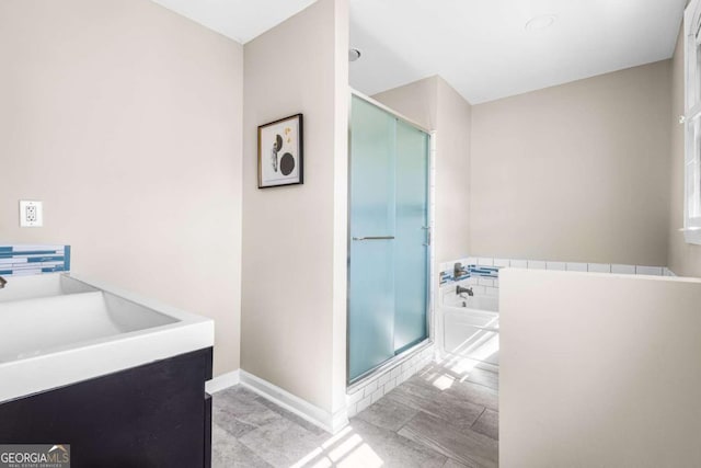 full bathroom with a sink, baseboards, a bath, and a shower stall