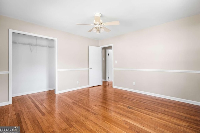 unfurnished bedroom with ceiling fan, a closet, baseboards, and wood finished floors