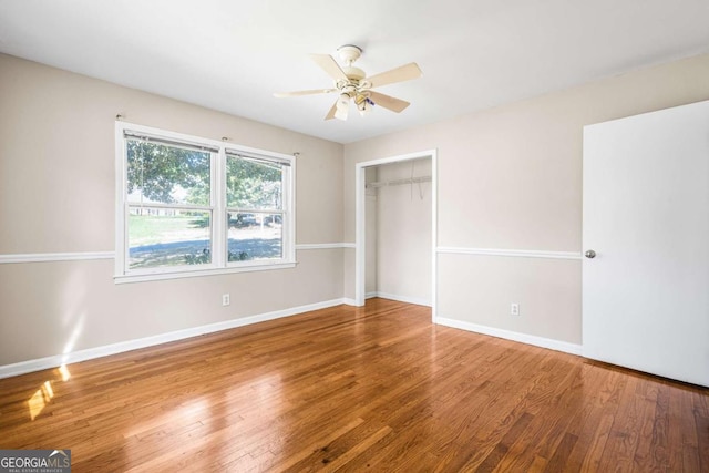 unfurnished bedroom featuring a closet, ceiling fan, baseboards, and wood finished floors