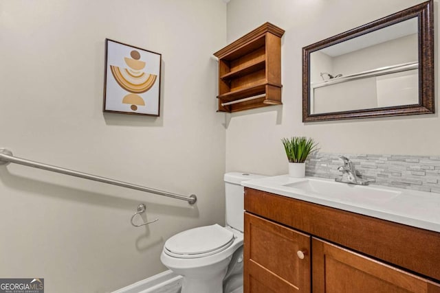 bathroom featuring decorative backsplash, baseboards, toilet, and vanity