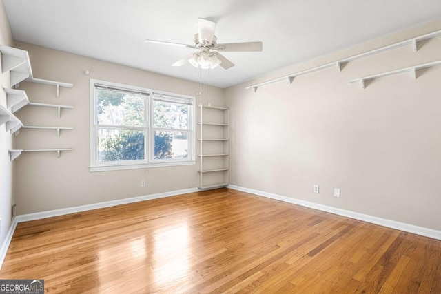 unfurnished room featuring a ceiling fan, light wood-type flooring, and baseboards