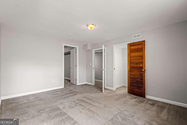 unfurnished bedroom with carpet, visible vents, and baseboards