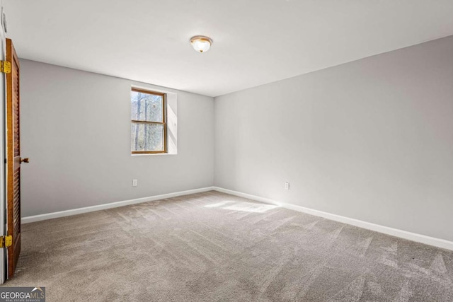 unfurnished room featuring baseboards and carpet floors