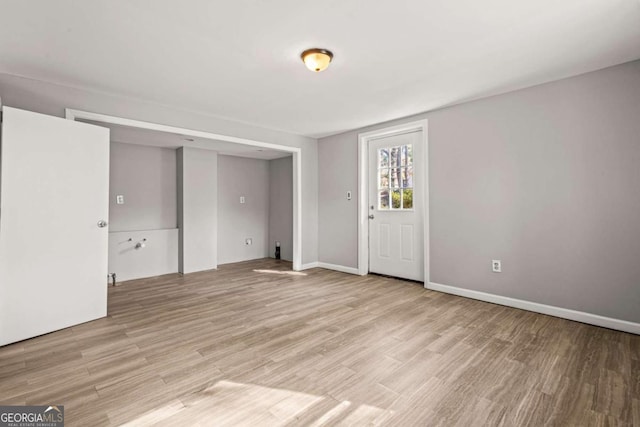 interior space with baseboards and light wood finished floors