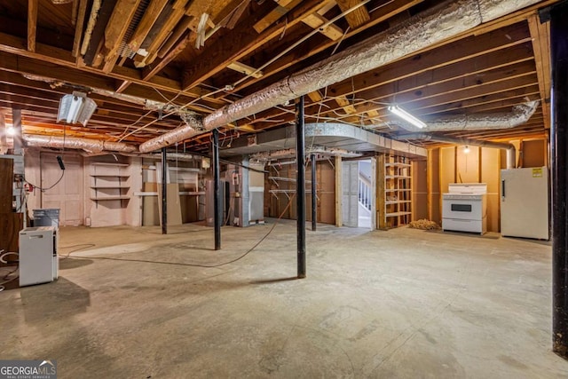 unfinished below grade area with heating unit, water heater, and freestanding refrigerator