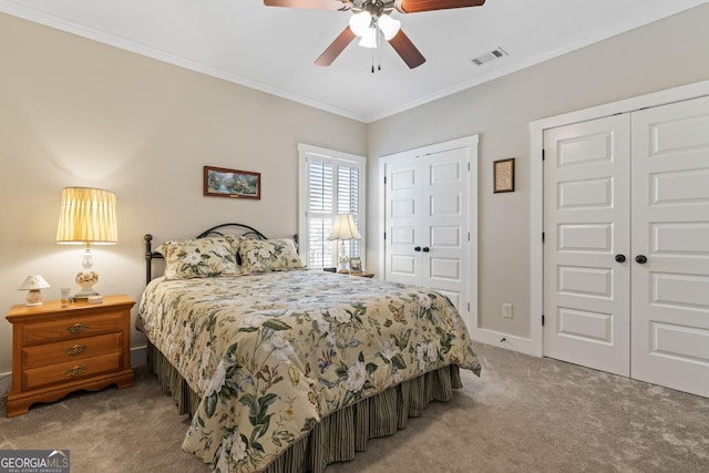 bedroom with visible vents, two closets, carpet, crown molding, and ceiling fan