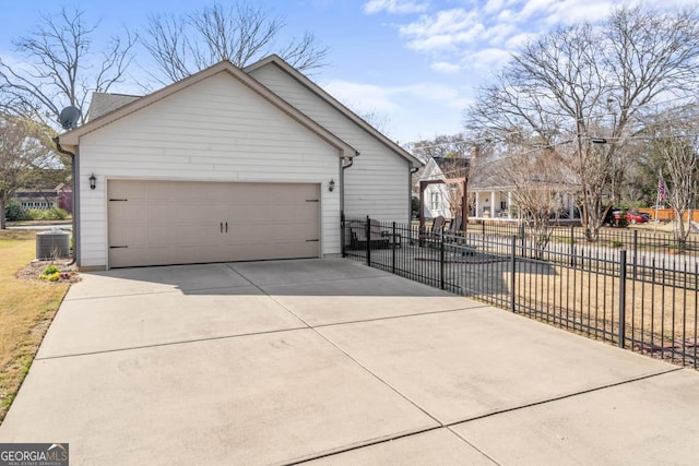 exterior space featuring central AC, fence, a garage, and driveway