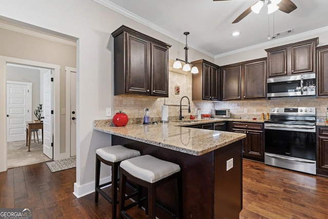 kitchen with dark brown cabinetry, backsplash, appliances with stainless steel finishes, and crown molding