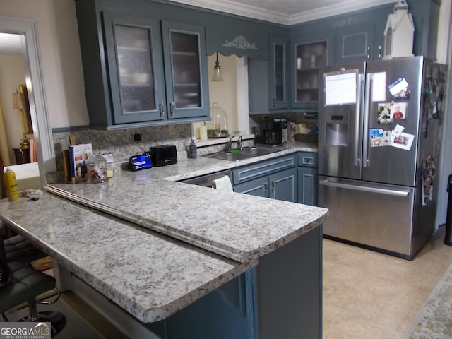 kitchen with ornamental molding, a sink, stainless steel appliances, a peninsula, and light countertops