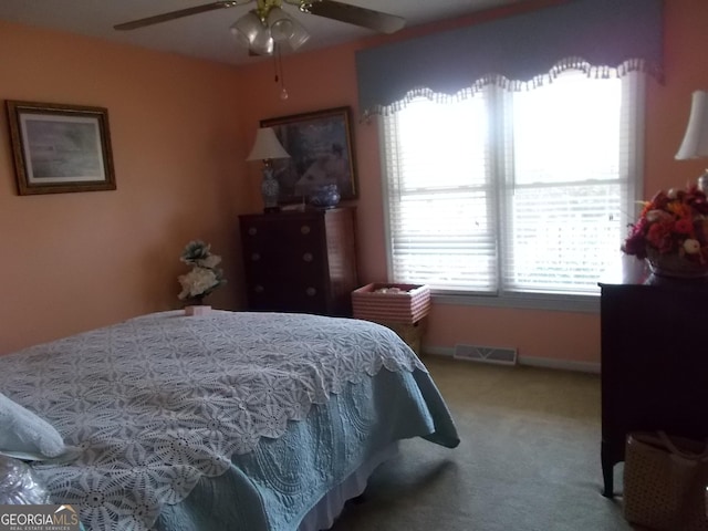 carpeted bedroom with visible vents, baseboards, and ceiling fan