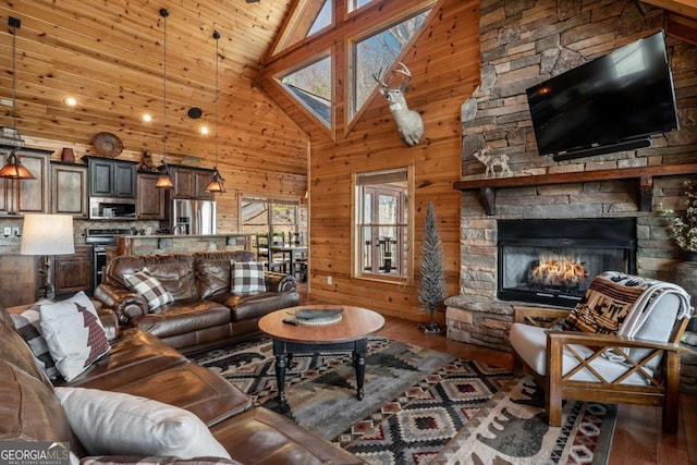 living room with a fireplace, wooden walls, wood finished floors, and high vaulted ceiling