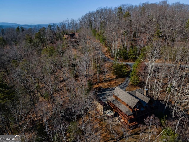 drone / aerial view featuring a wooded view