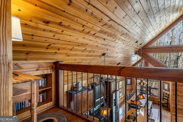 hall featuring wood finished floors, wood walls, wood ceiling, and vaulted ceiling