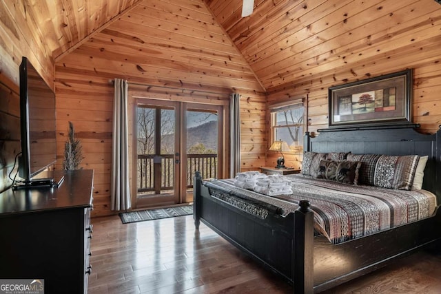 bedroom featuring access to outside, wood walls, wood finished floors, and vaulted ceiling