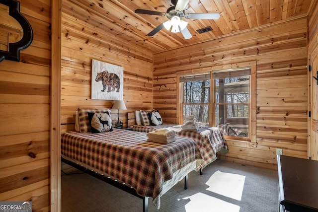 bedroom with visible vents, wood walls, wooden ceiling, and carpet flooring