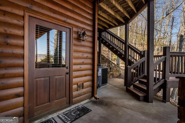 property entrance with central air condition unit and faux log siding