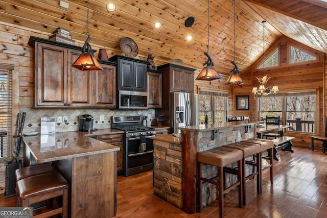 kitchen with dark wood-style floors, stainless steel appliances, an inviting chandelier, a breakfast bar area, and wood ceiling