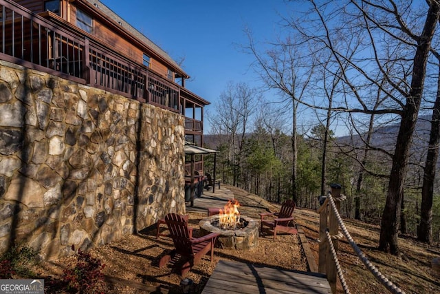 view of yard featuring a balcony and an outdoor fire pit