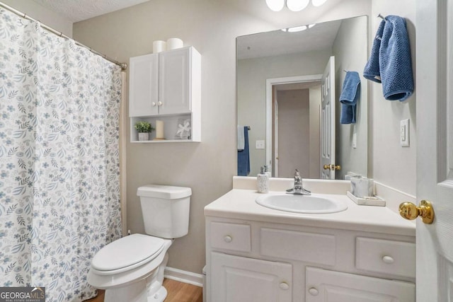 bathroom with vanity, toilet, a shower with curtain, and baseboards