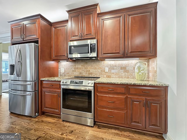 kitchen featuring light stone counters, stainless steel appliances, backsplash, and dark wood finished floors