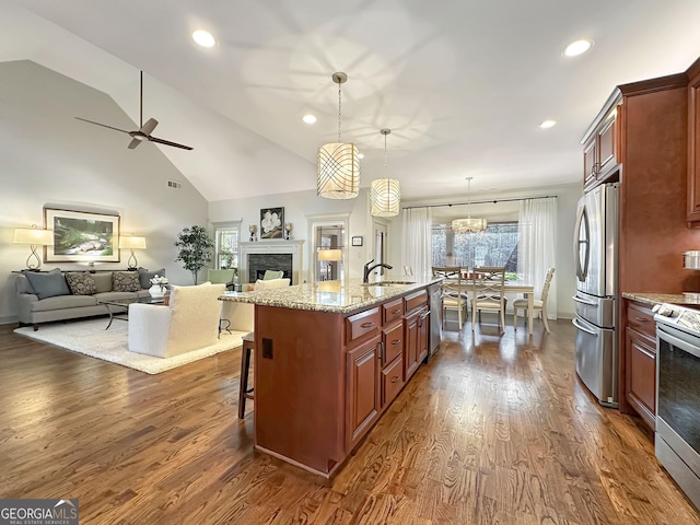 kitchen with stainless steel appliances, dark wood finished floors, open floor plan, and a fireplace