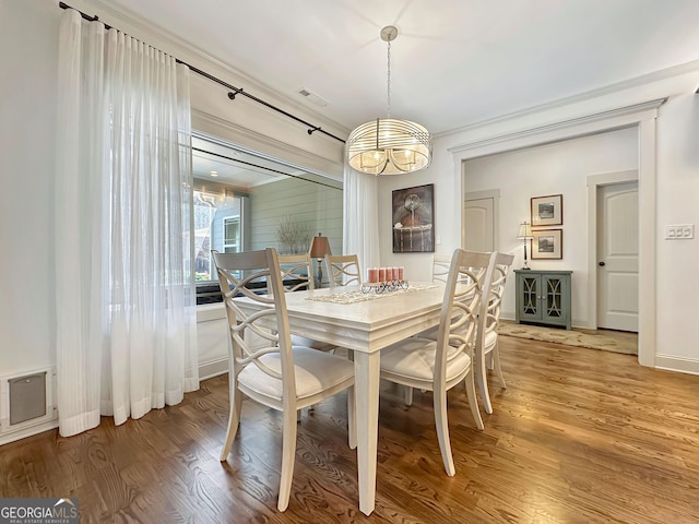 dining area featuring a chandelier, light wood-style flooring, and baseboards