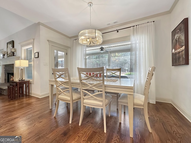 dining room with visible vents, crown molding, baseboards, and wood finished floors