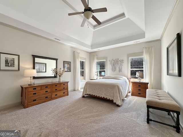 carpeted bedroom featuring visible vents, crown molding, a raised ceiling, and ceiling fan