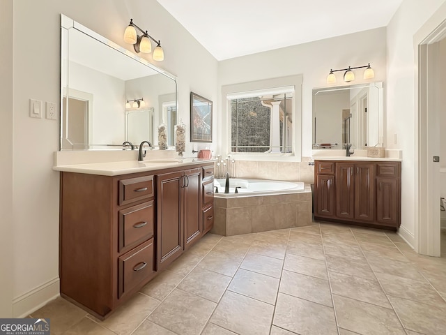 full bath featuring a sink, a garden tub, two vanities, and tile patterned flooring