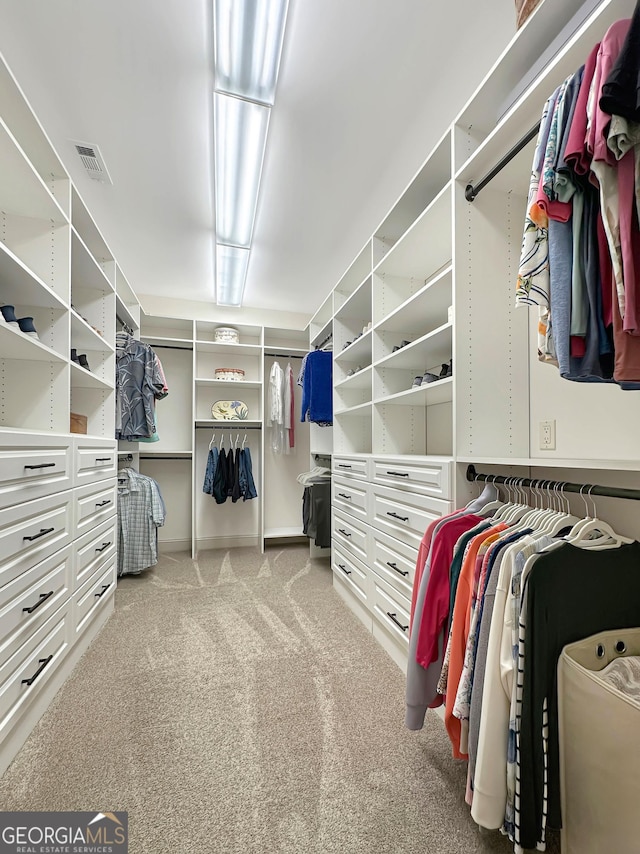 walk in closet featuring visible vents and carpet