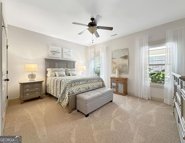 carpeted bedroom with a ceiling fan, baseboards, and visible vents