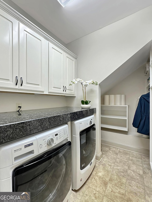 laundry area featuring baseboards, cabinet space, and washing machine and clothes dryer