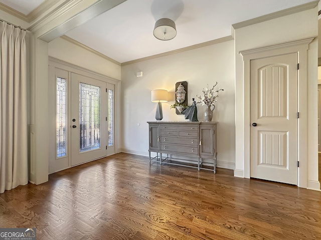 entryway with crown molding, baseboards, and wood finished floors