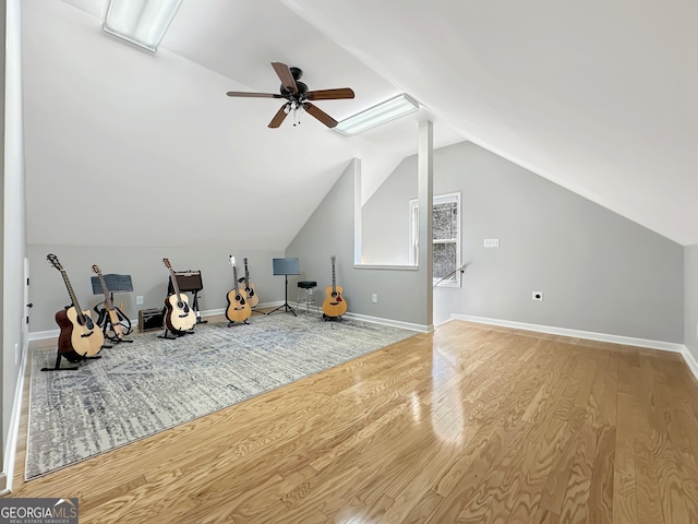 additional living space featuring lofted ceiling, wood finished floors, baseboards, and ceiling fan