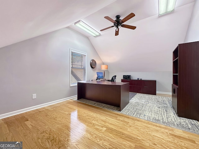 office featuring vaulted ceiling, a ceiling fan, light wood-type flooring, and baseboards