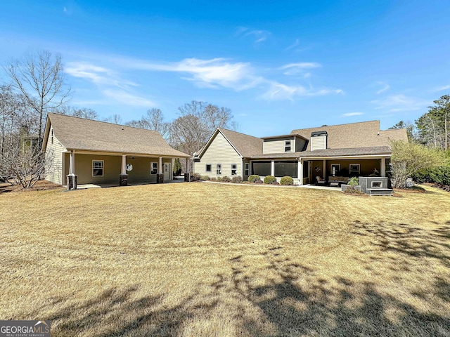 rear view of property featuring a patio and a yard