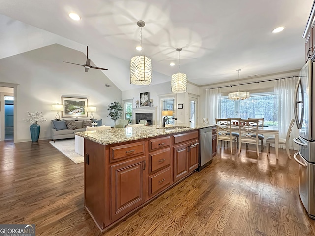 kitchen featuring dark wood-style floors, open floor plan, appliances with stainless steel finishes, and a sink