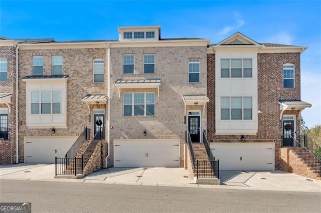 multi unit property featuring concrete driveway, brick siding, and a garage