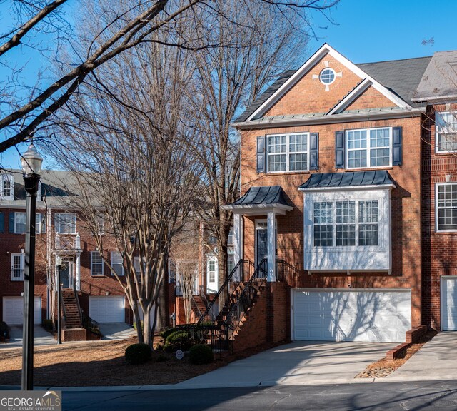 view of property featuring brick siding, an attached garage, and concrete driveway